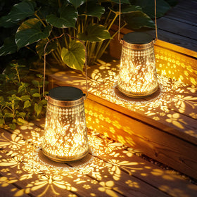 Ahaorigin 2-pack solar lanterns with hollow butterfly silhouettes illuminate a garden.