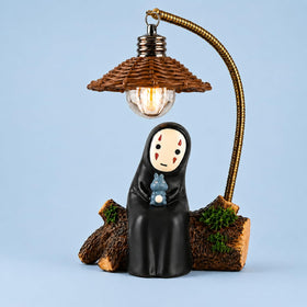 Amallino No Face Lamp on a desk with a soft resin glow for a cozy workspace.