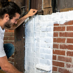 AMES flexible waterproof membrane drying on a vertical wall surface.