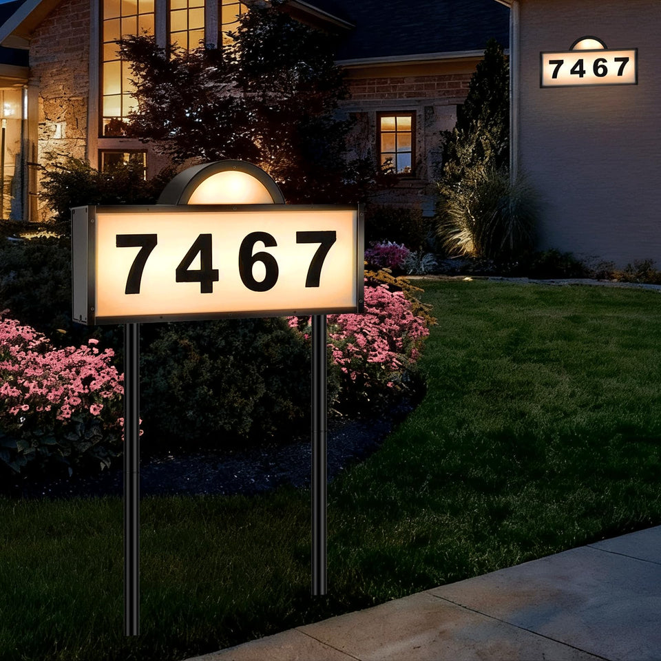 Aqonsie solar address sign mounted on exterior wall for clear nighttime visibility.