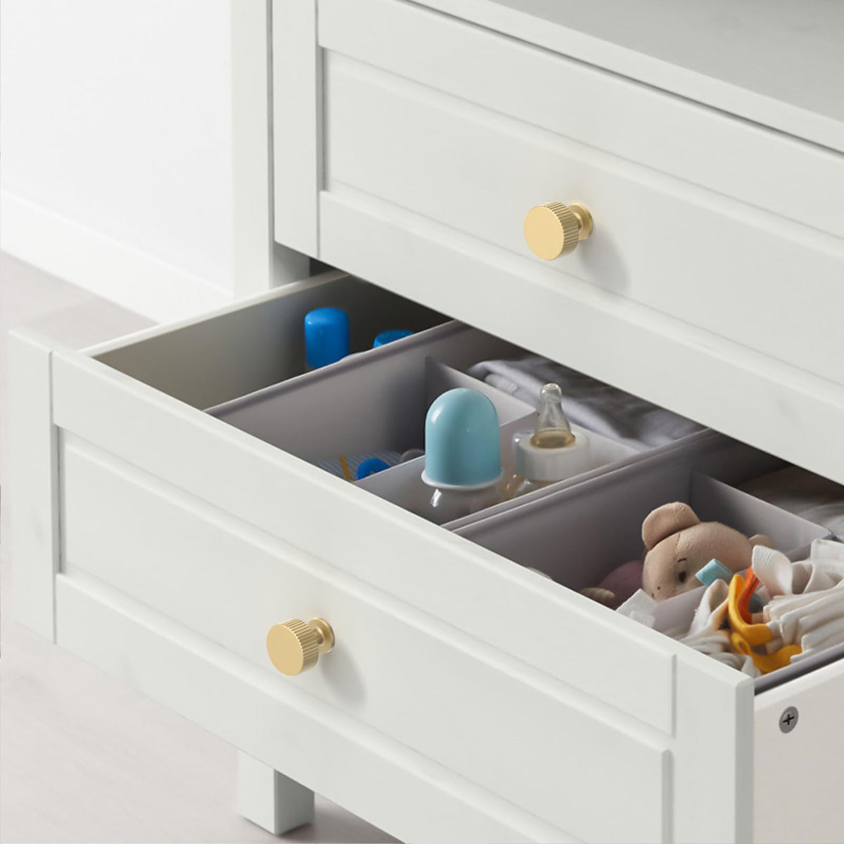 Asidrama brushed gold drawer knobs installed on a dark dresser for contrast