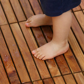 Bare Decor teak tiles snapped together for floating installation on a surface.