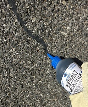 Blue Star asphalt crack filler during driveway application demonstrates sealing cracks to prevent damage