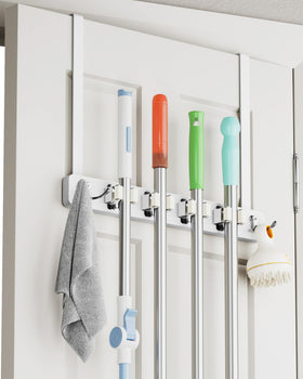 BS-VOG over-the-door broom holder with four racks and two hooks keeps cleaning tools organized.