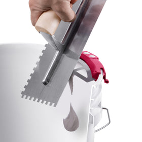 Bucky Scrape attached to bucket edge for cleaner walls and easier adhesive retrieval