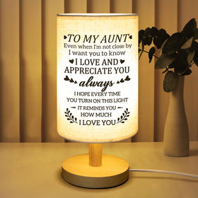 Calibron fabric lamp with wooden stand adds warm ambiance to a nightstand