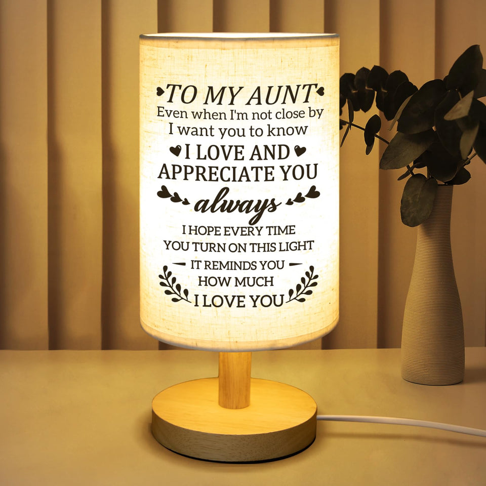 Calibron fabric lamp with wooden stand adds warm ambiance to a nightstand