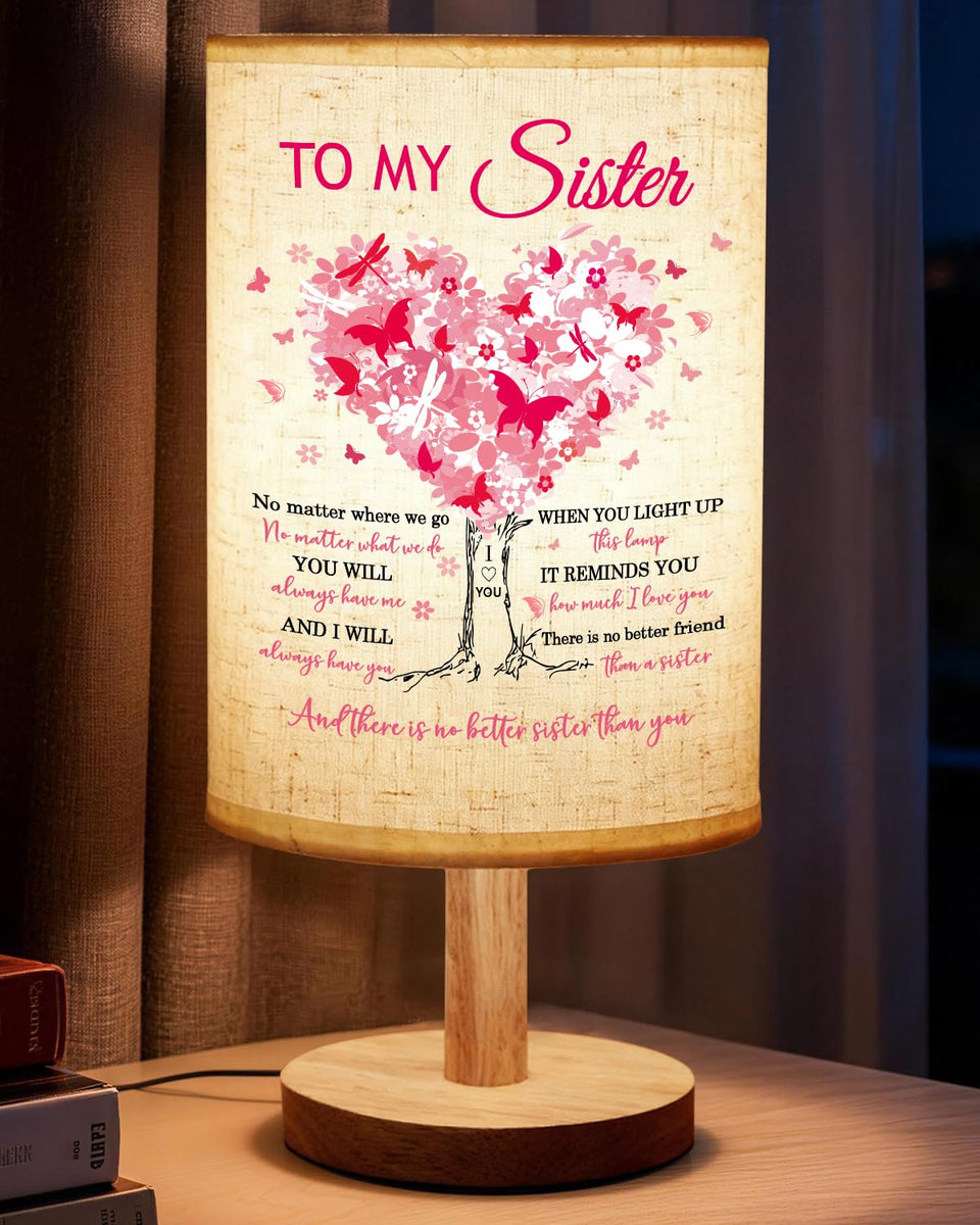 Calibron sister table lamp with wooden stand creates warm bedside ambiance.