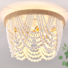 Capslpad wood-beaded flush mount chandelier for ambient dining room lighting.