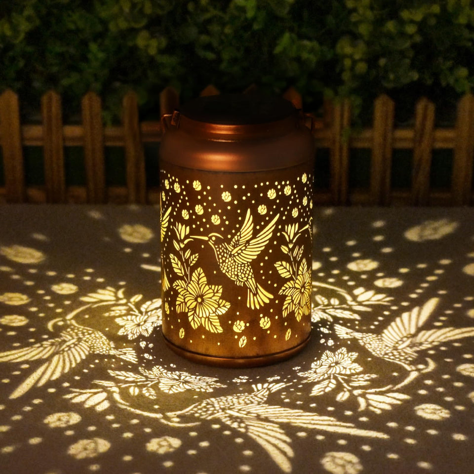 Cawalap hummingbird lantern hanging on a tree for warm garden ambiance
