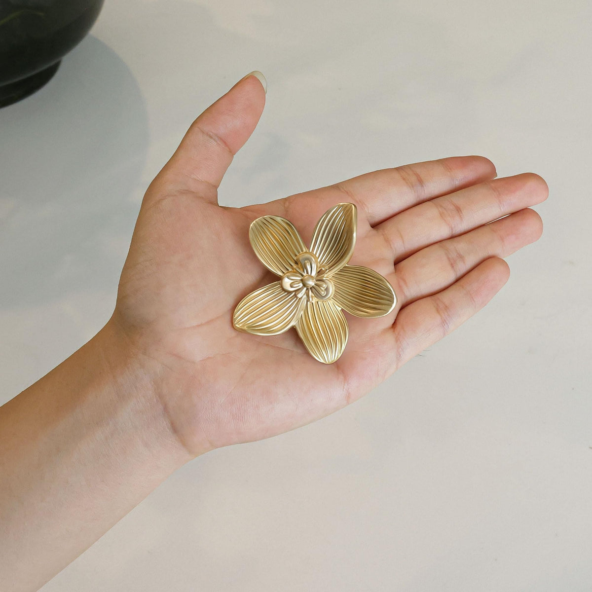 CEYMIO brushed gold flower knob on a vanity or dresser in soft light