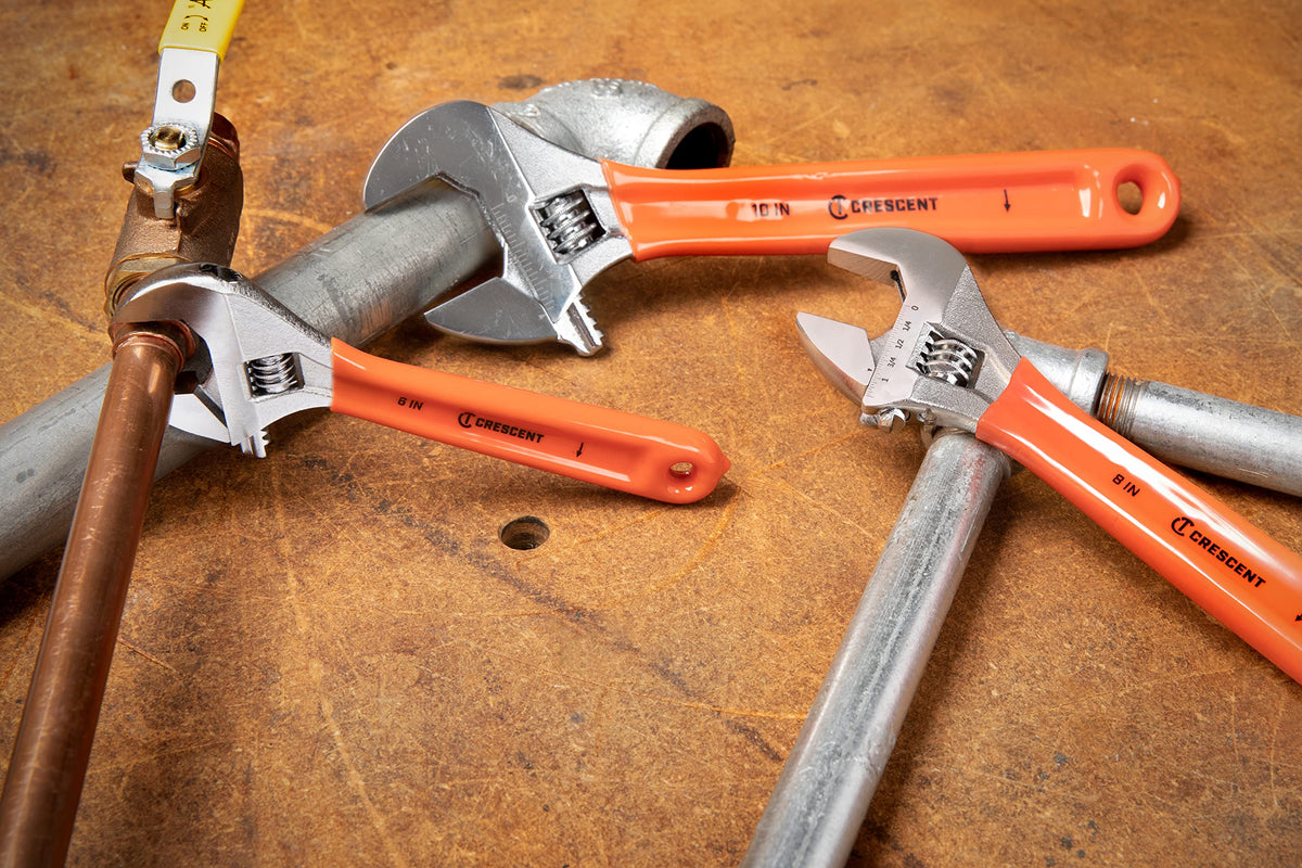 Crescent wrench set in action on a plumbing task.
