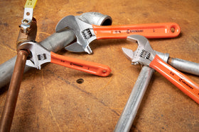 Crescent wrench set in action on a plumbing task.