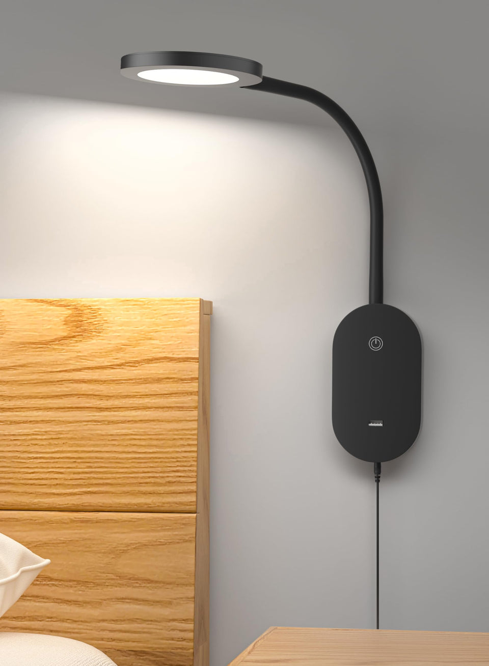 Deeloop LED wall lamp beside bed provides even bedside illumination.