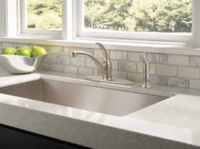 Delta Foundations brushed nickel faucet with side sprayer illustrating versatile spray options for efficient cleaning.
