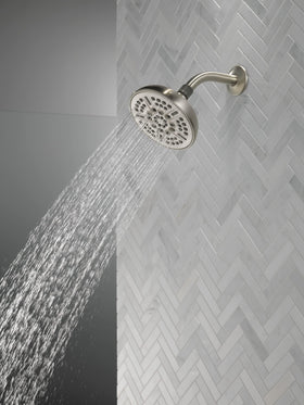 Delta brushed nickel shower head showing the full-body spray for even coverage.