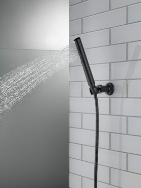 Delta Trinsic matte black hose extended for flexible reach during rinsing.