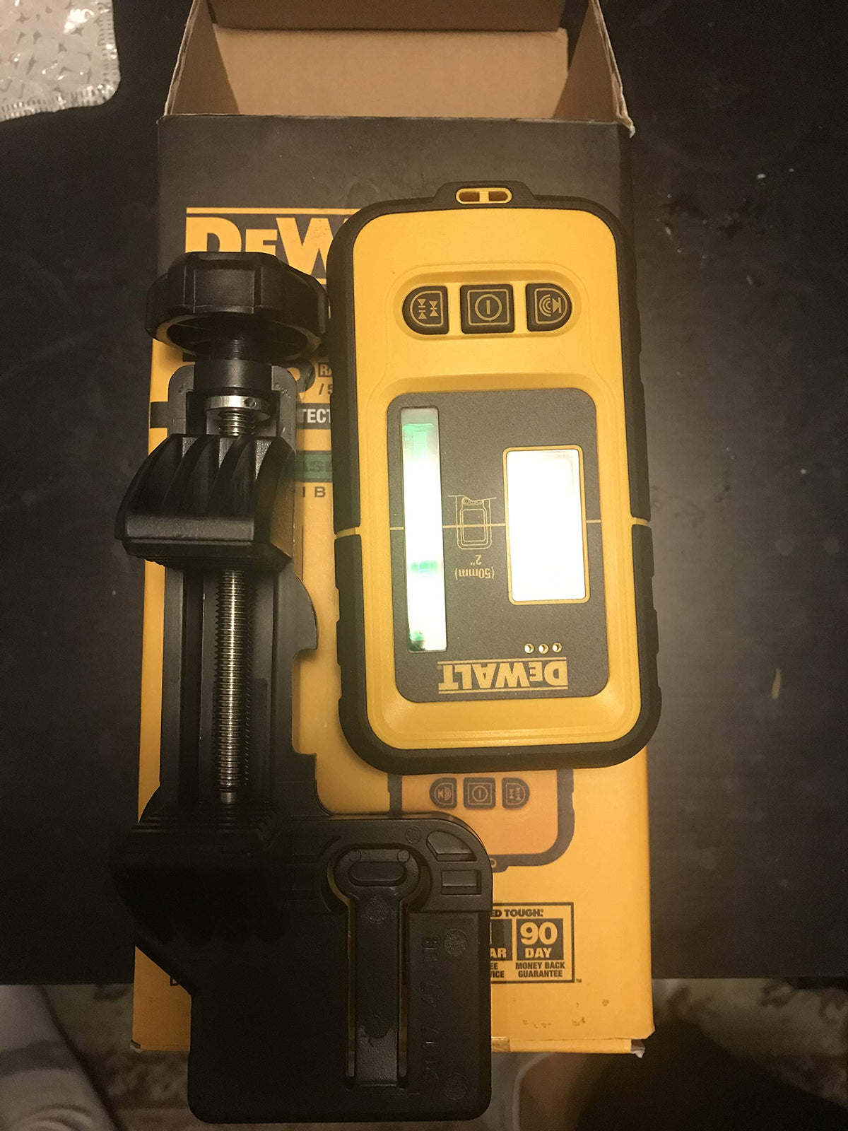 DEWALT DW0892G green laser detector in use on a ceiling track for alignment.