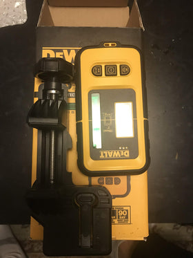 DEWALT DW0892G green laser detector in use on a ceiling track for alignment.