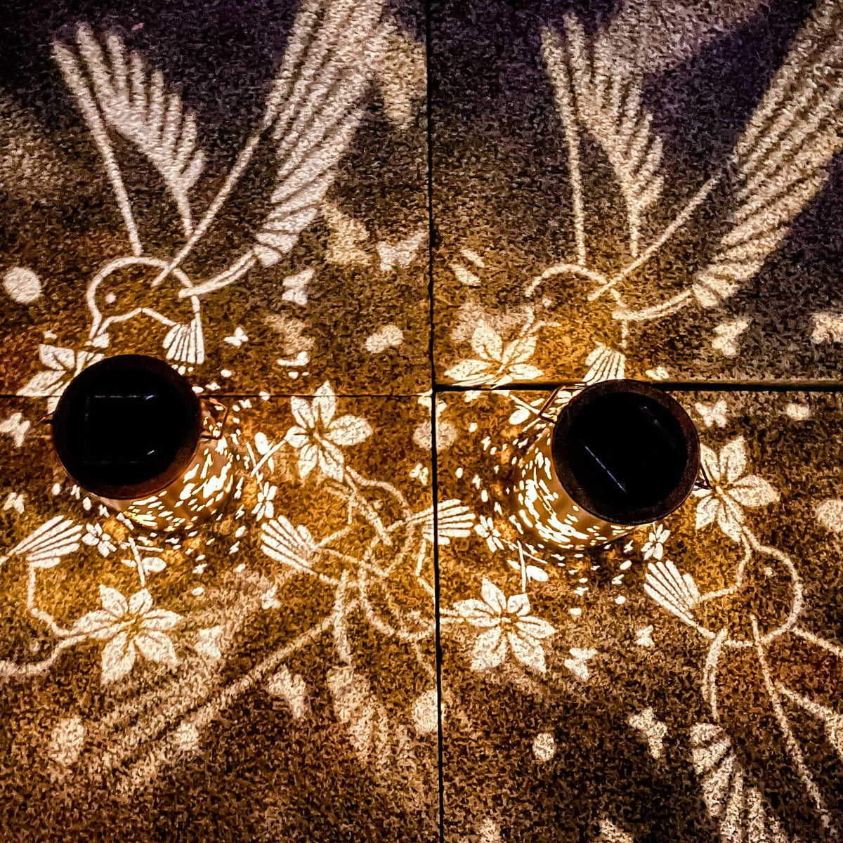 DIBIEECN hummingbird-pattern lantern casts warm light along walkways.