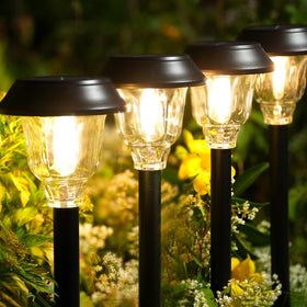 DOESLAG solar pathway light with metal frame and glass shade offers warm, inviting illumination.