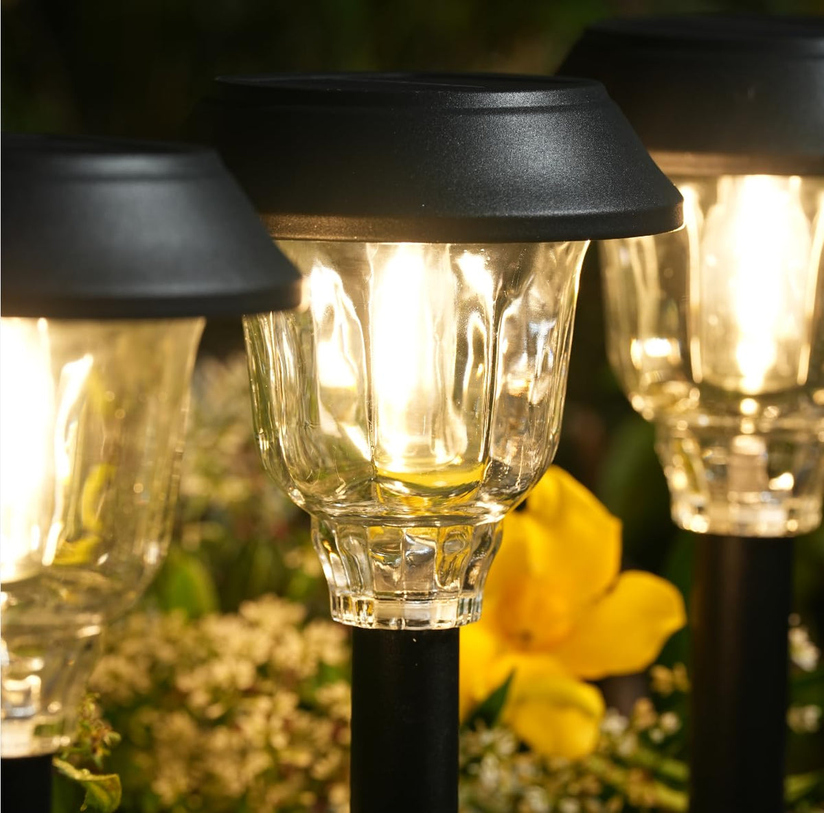 DOESLAG glass shade creates decorative light patterns along garden path.
