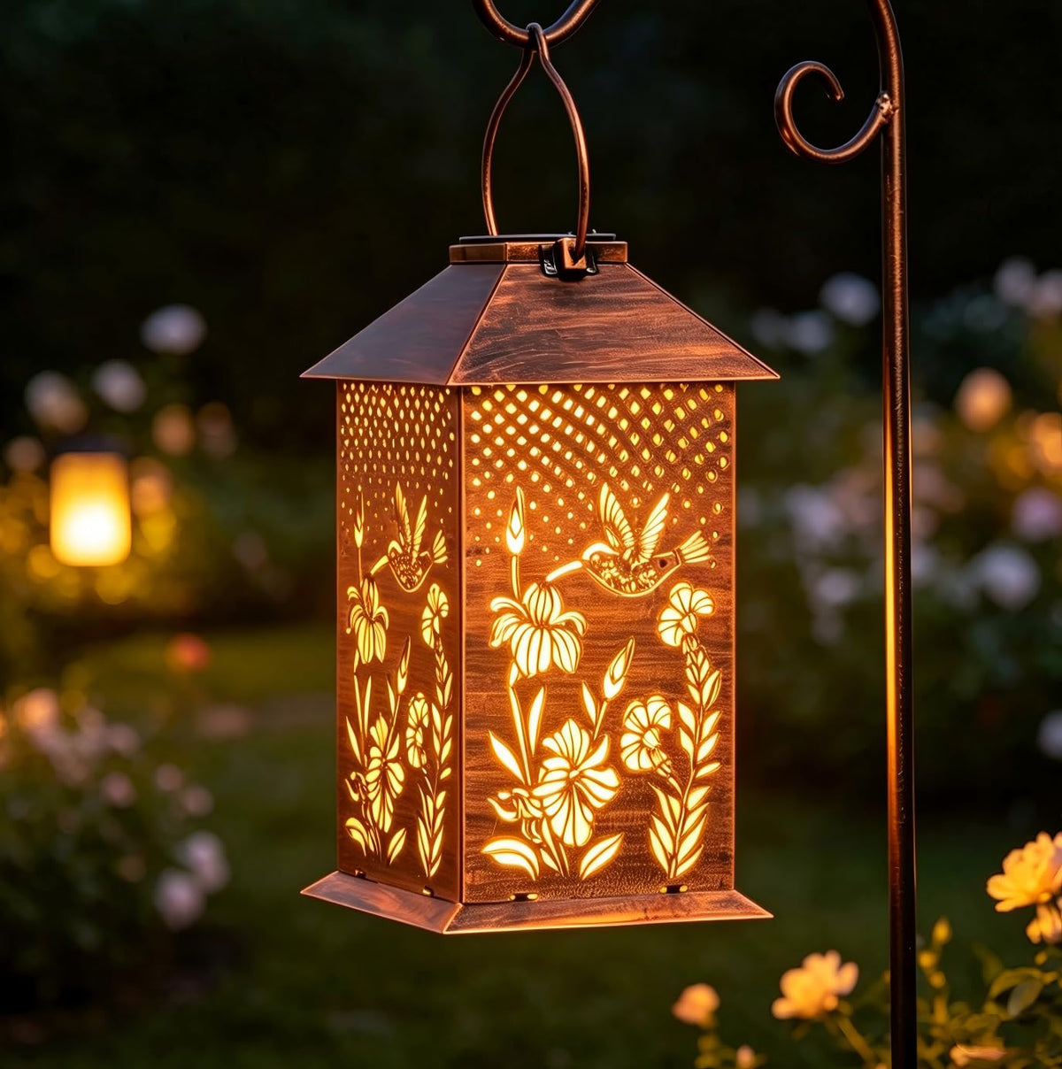 Doorkeer hummingbird solar lantern at dusk casts decorative patterns on the patio