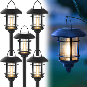 Dynaming 6-pack solar path light on ground stake casting warm glow.