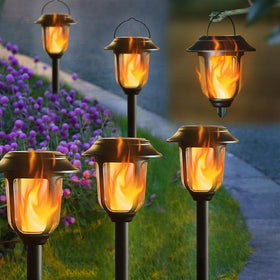 Dynaming dual-use solar flame light lighting a garden path with warm glow.