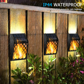 Dynaming solar flame wall light along yard decor for a welcoming border.