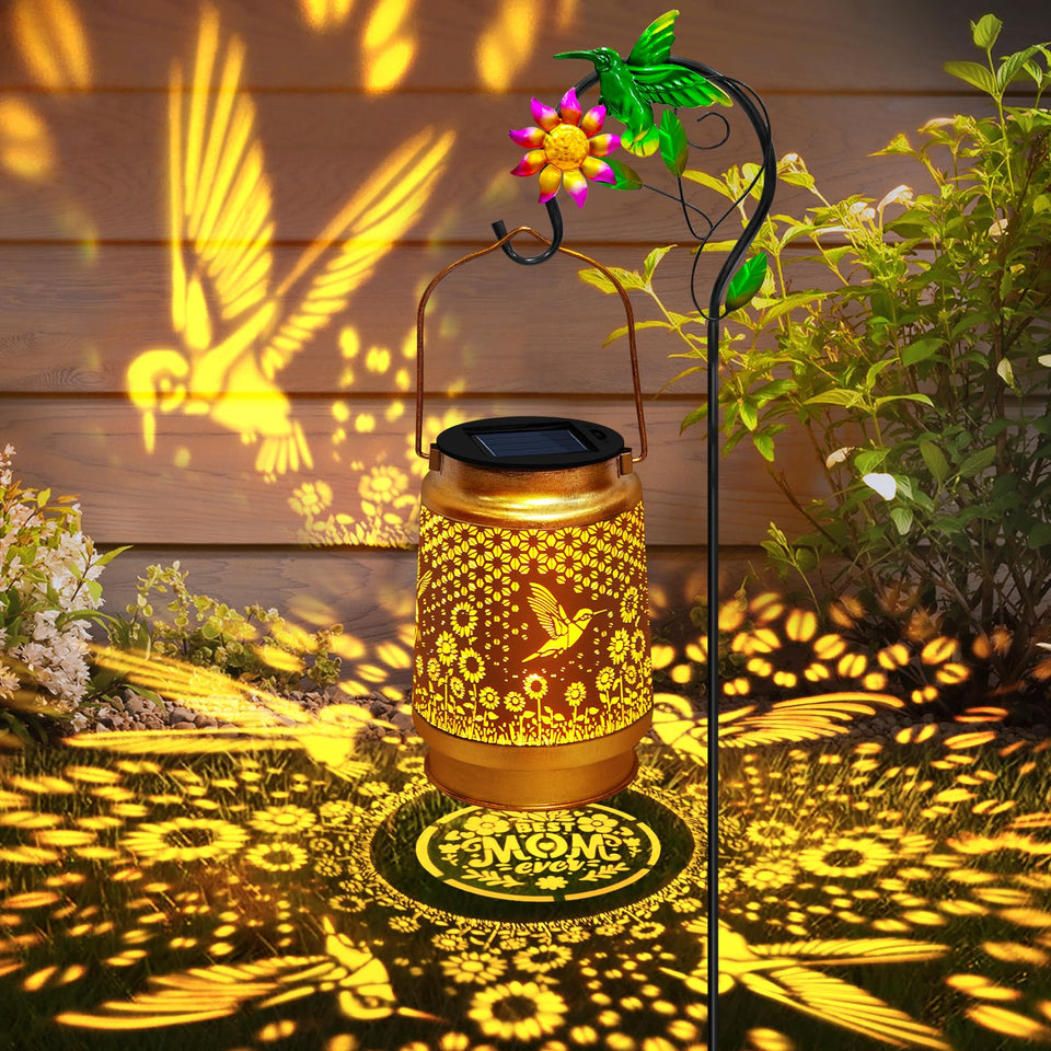 EDOF hummingbird solar lantern with shepherd hook creates warm garden lighting.
