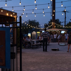 Enbrighten black cord string lights create sleek contrast on dark exteriors.