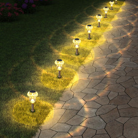 Eyrosa solar mushroom light head illuminates garden with warm white glow.