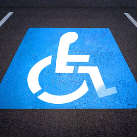 EYUNSTAR handicap parking stencil 36x36 laid on asphalt for precise, reusable markings.