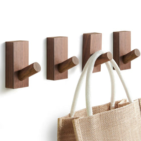Felidio walnut wall hooks four-pack displayed on wall for organized entryway.