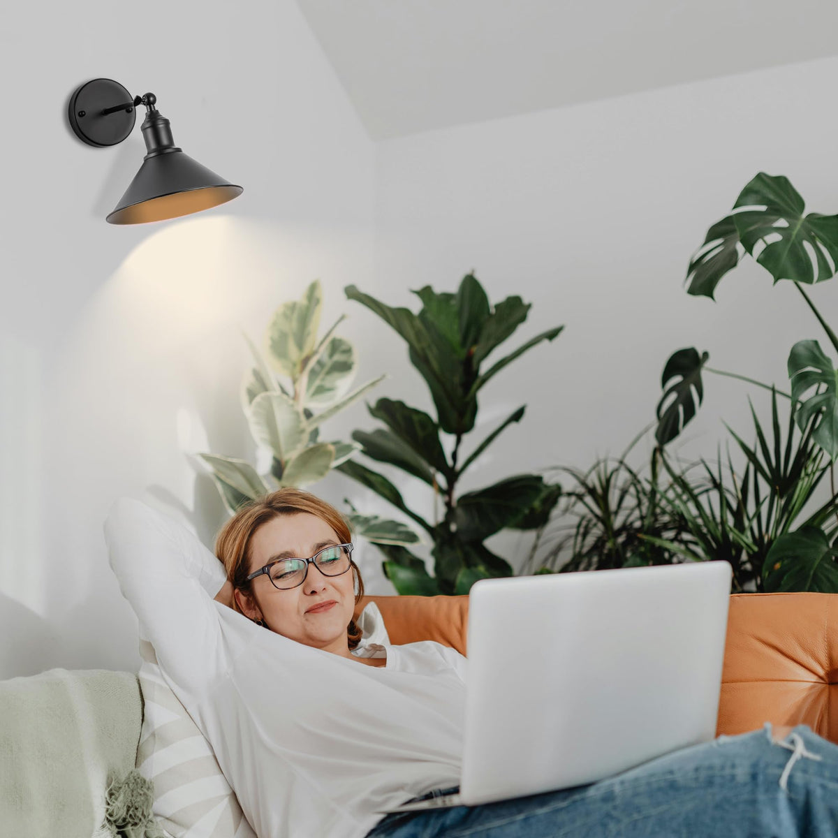 Franing wireless sconce remote control in hand to adjust brightness and timer