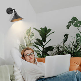 Franing wireless sconce remote control in hand to adjust brightness and timer