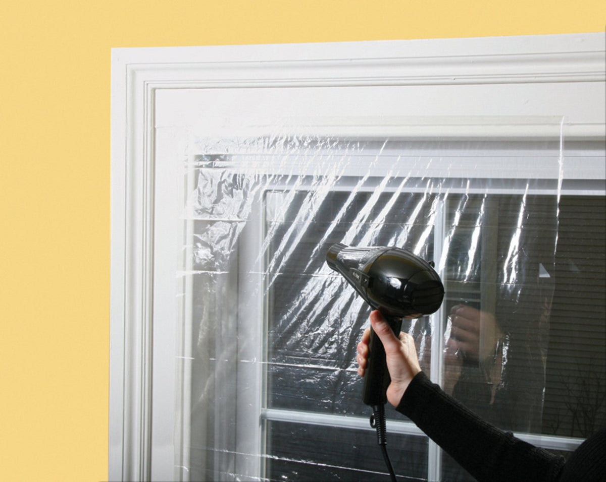 Finished window with clear insulating film and near invisible appearance