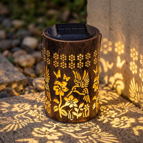 Fussion solar lantern with hummingbird cutout glowing in garden ambiance