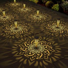 Gardencave mandala solar light projects a warm pattern along the garden path.
