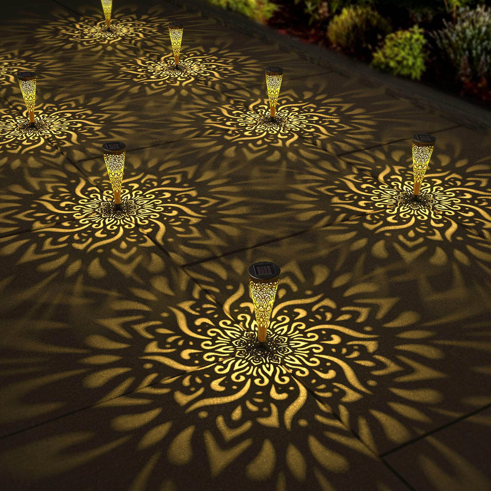 Gardencave mandala solar light projects a warm pattern along the garden path.