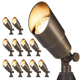 Gardencoin brass spotlight with bronze finish highlights garden paths.