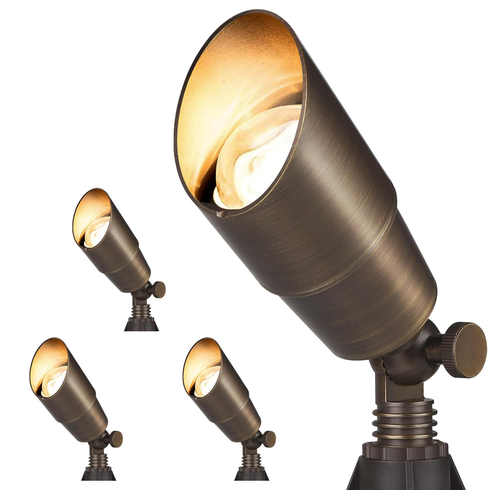 Gardencoin brass spotlight in front view highlighting a garden path with a durable finish.