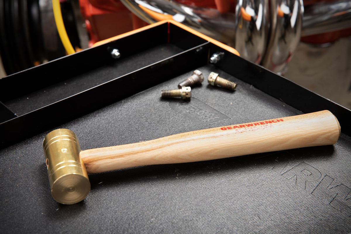 GEARWRENCH brass hammer in use, driving bushings with minimal surface damage.