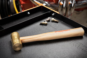 GEARWRENCH brass hammer in use, driving bushings with minimal surface damage.