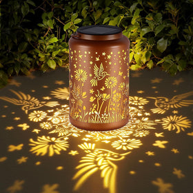 GOLFOEE solar lantern with hummingbird pattern casts a warm glow in the garden.