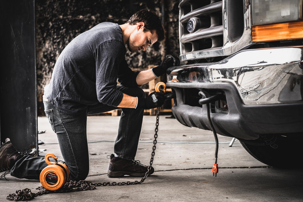 Gorilla Grip work gloves on hand during oil change demonstration for safety.