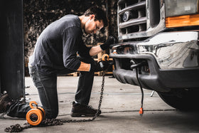 Gorilla Grip work gloves on hand during oil change demonstration for safety.
