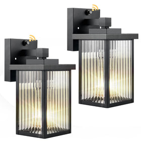 Hameso dusk-to-dawn sconce with textured glass lighting the front door