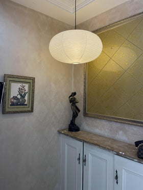 Henjjras white chandelier shade above sofa arrangement.